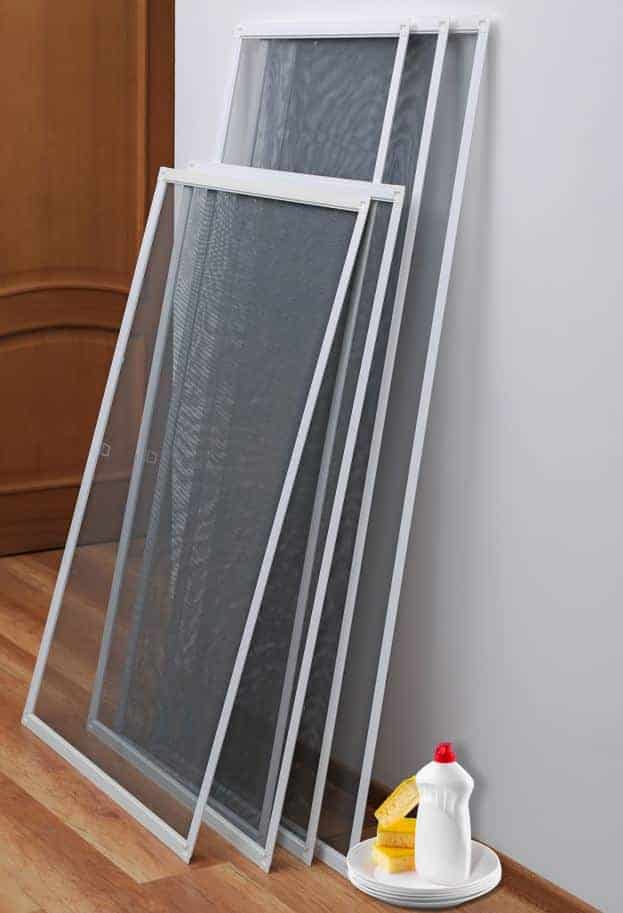 flyscreens placed on a wall adjacent to wooden floors with a dish soap bottle next to them