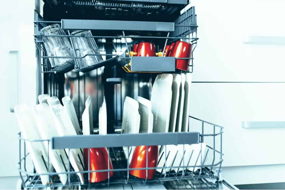 open dishwasher full of red cups and white dishes