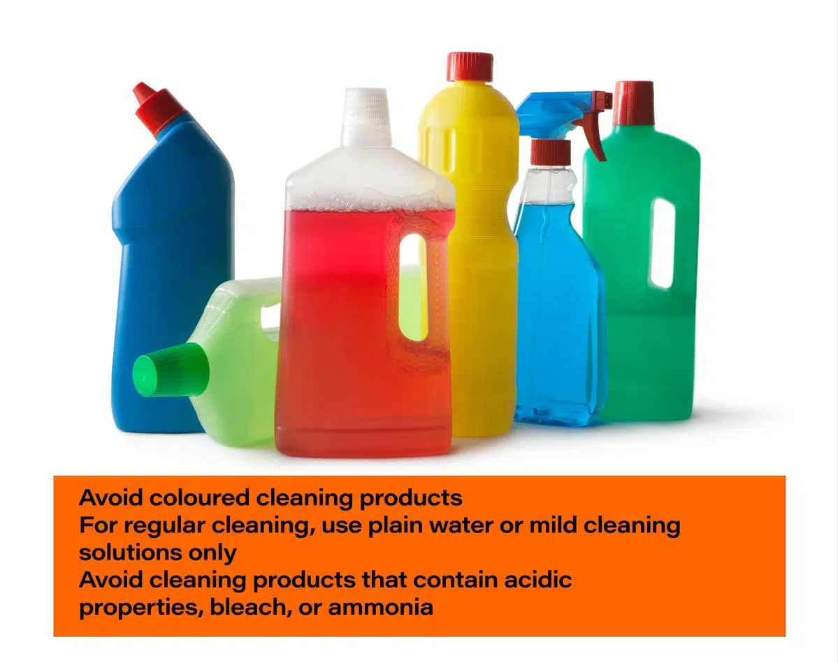 assorted coloured cleaning bottles lined up on a white background