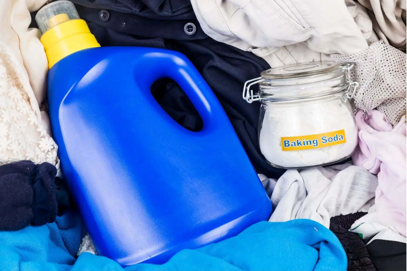 baking soda and laundry detergent sitting on top of a pile of clothes
