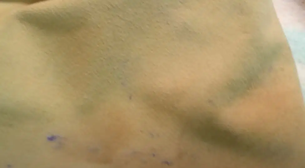 blue ink on light brown suede handbag