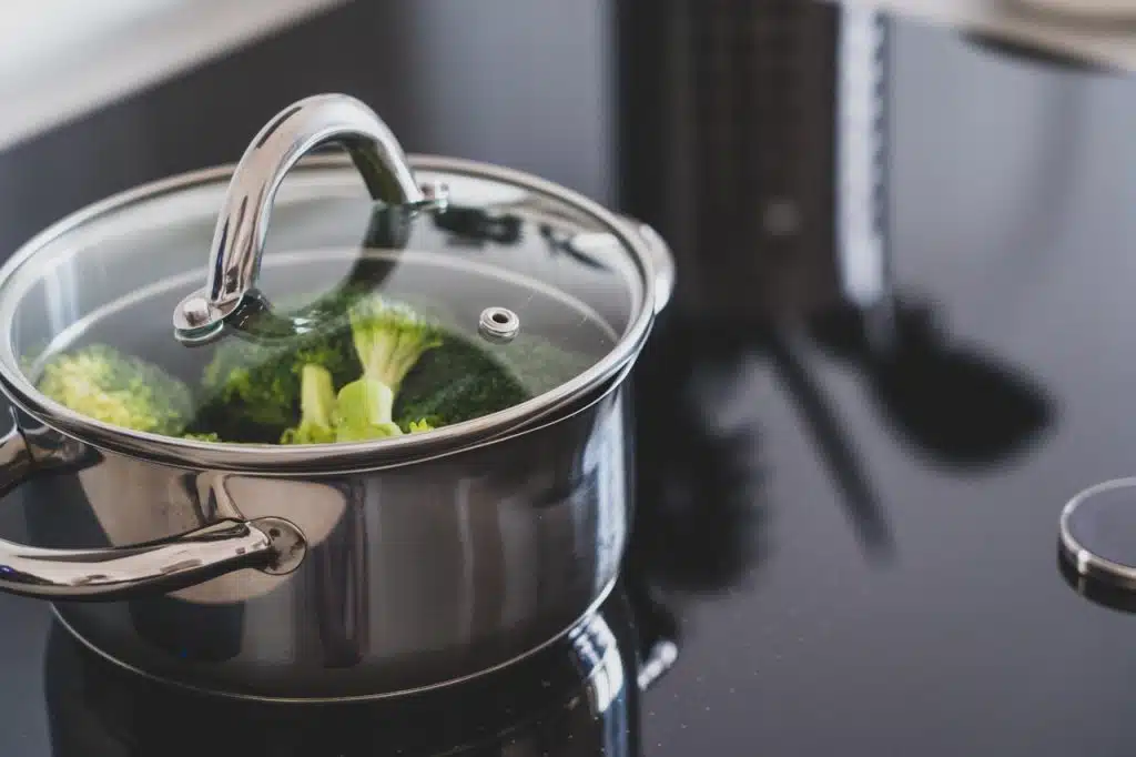 Brocolli being cooked in a stainless steel pot
