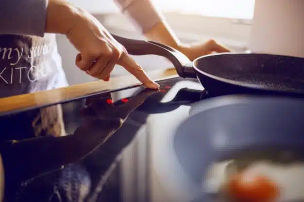 woman apron adjusting temperature stove