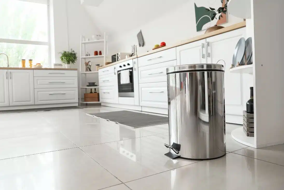 close up of large stainless steel clean rubbish bin with white inspired kitchen in the background