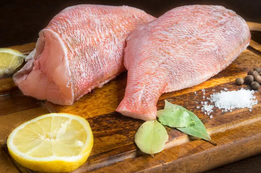 filleted fish on a chopping board next to lemon and rock salt