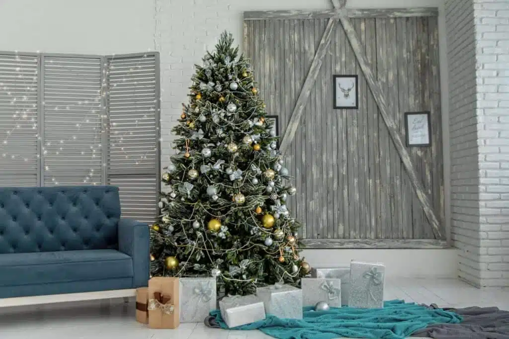 A green christmas tree with presents wrapped in gray wrapping paper underneath,