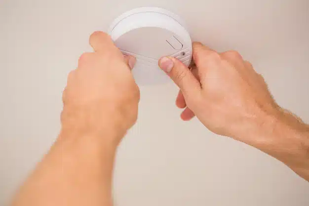 Handman installing smoke detector