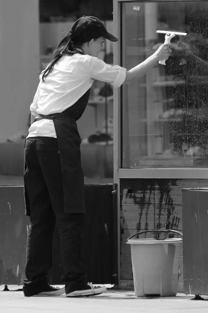 hospitality worker cleaning external windows