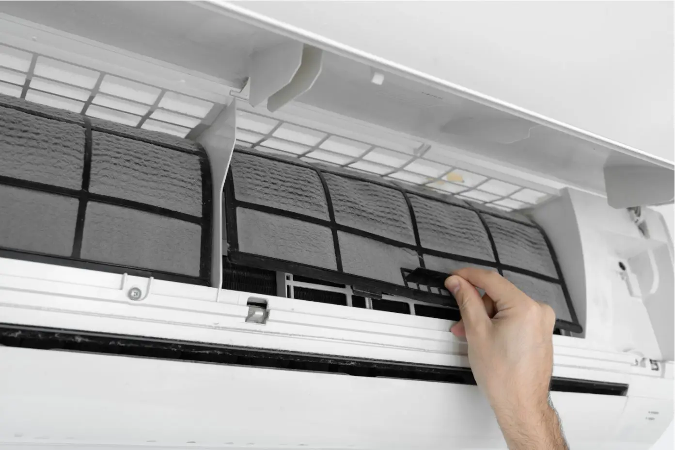 man checking ac filter in airconditioning unit