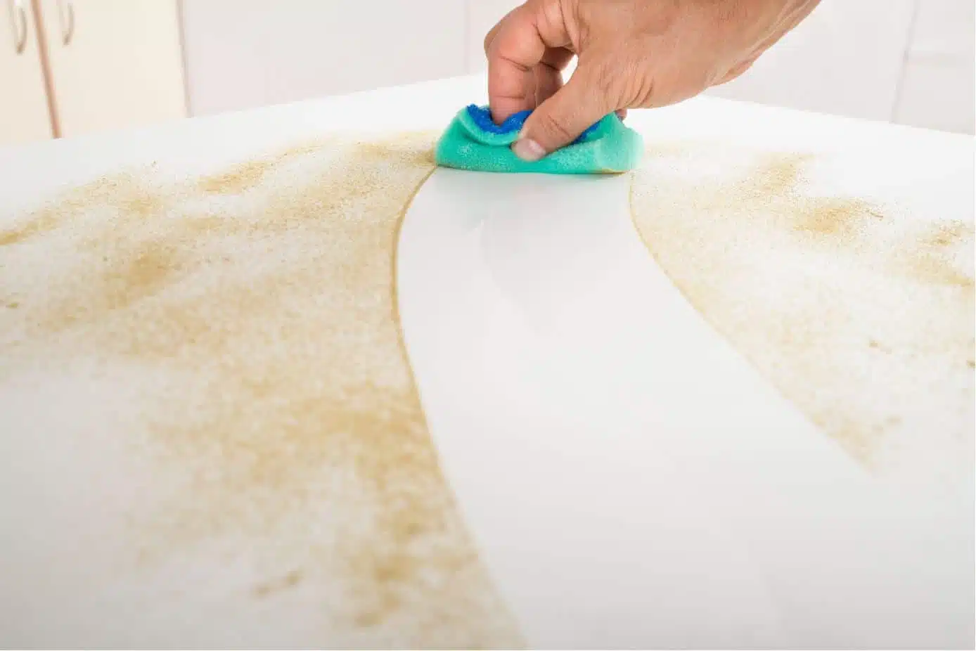 man cleaning dirty countertop with sponge