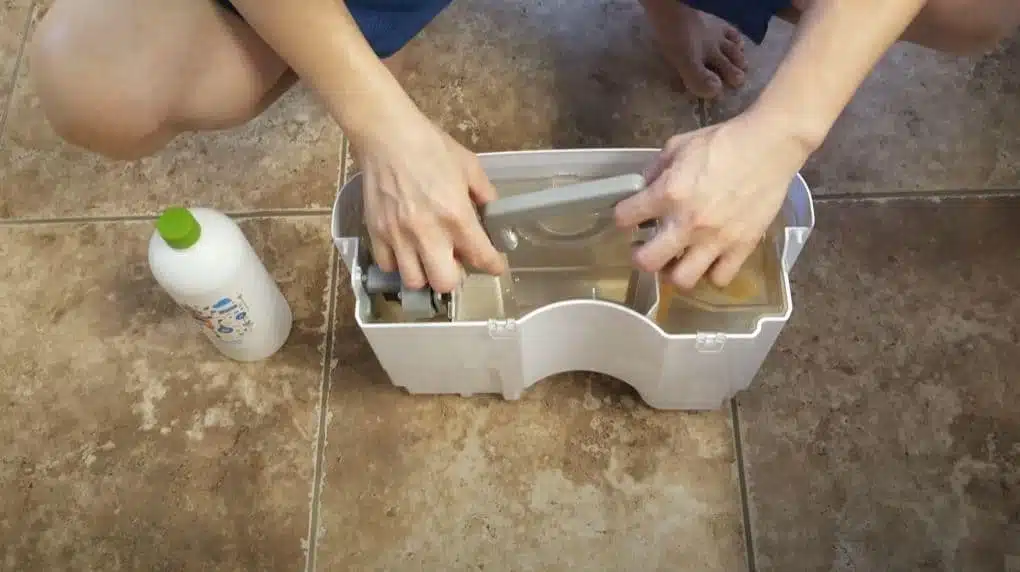 man cleaning reservoir of a frigidair dehumidifier