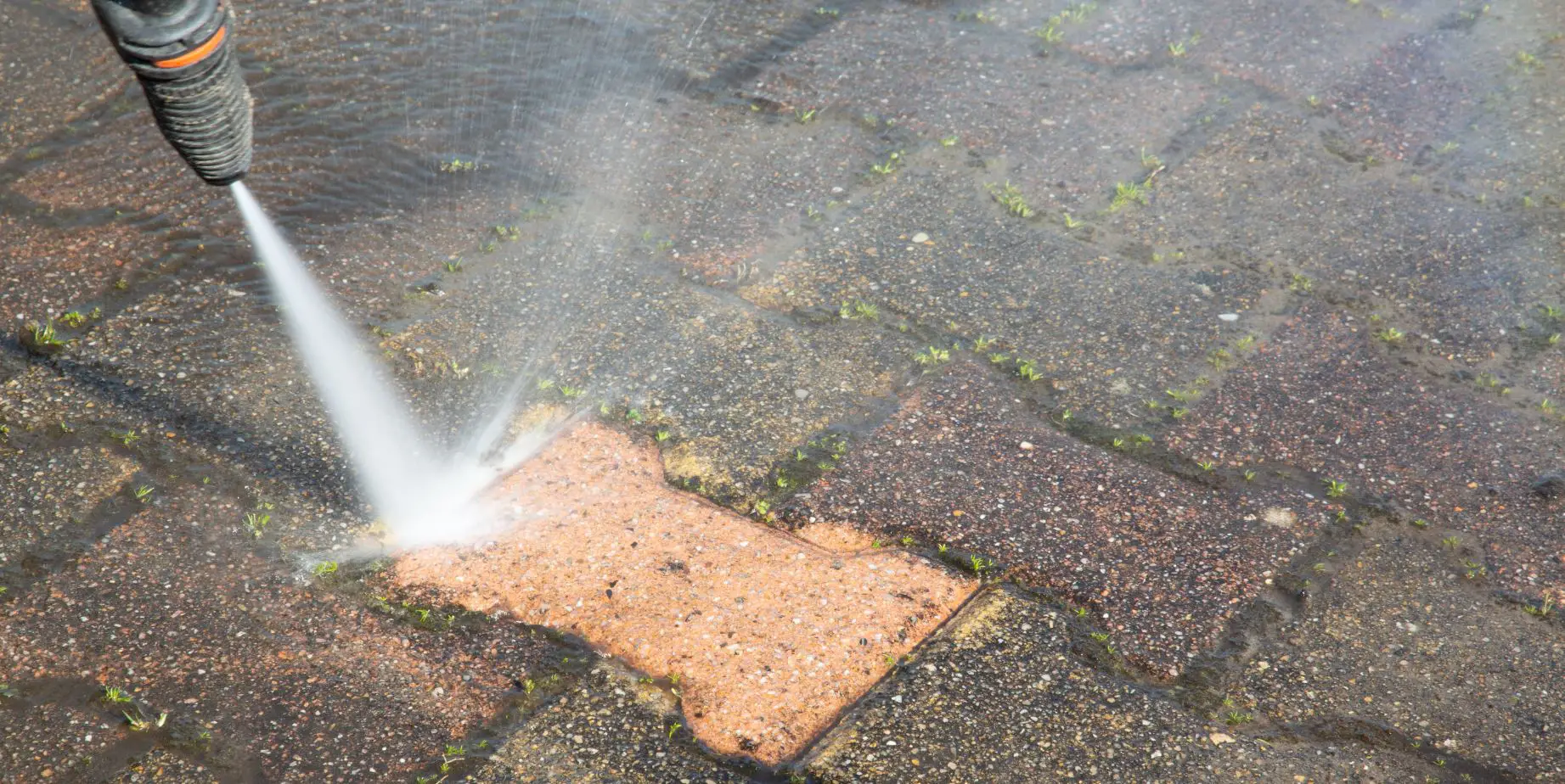 pressure washing dirty pavement tiles