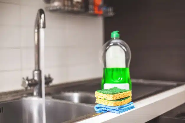 Sponges to clean in the foreground and detergent.