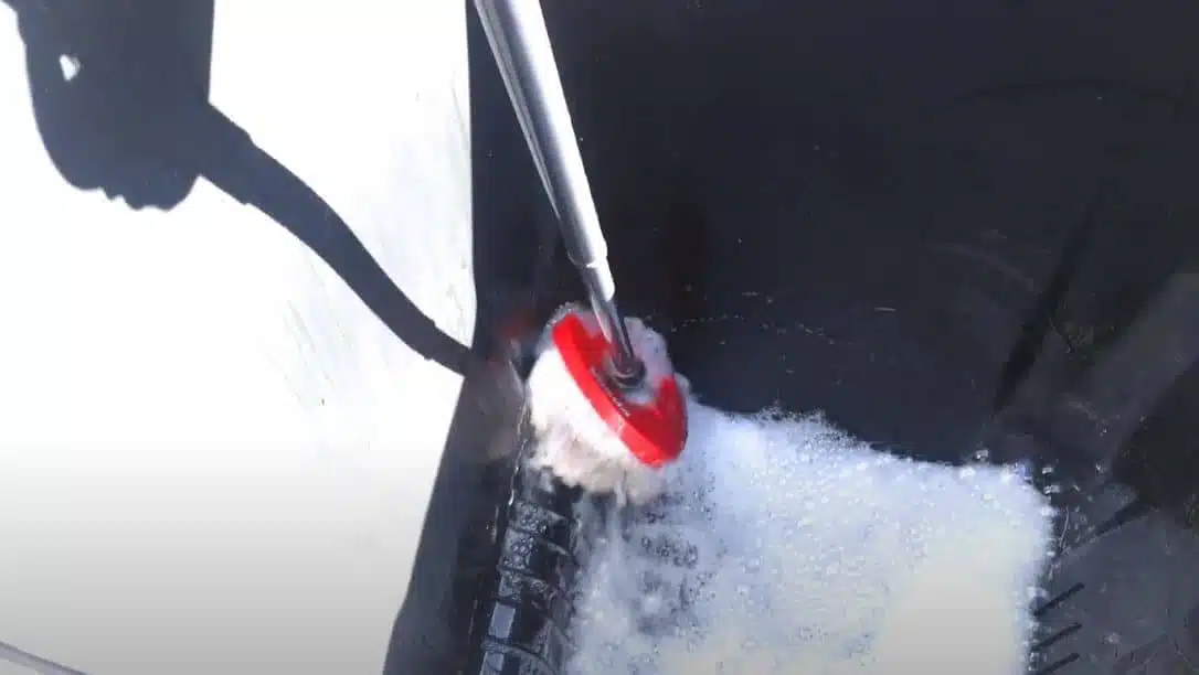 the interior of a wheelie bin being cleaned with soap and water