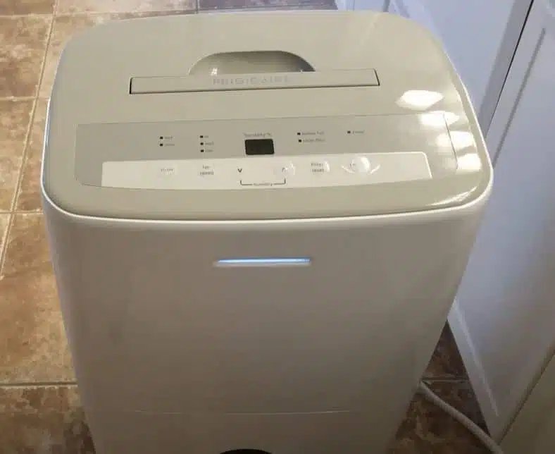 white frigidaire dehumidifier exterior being cleaned