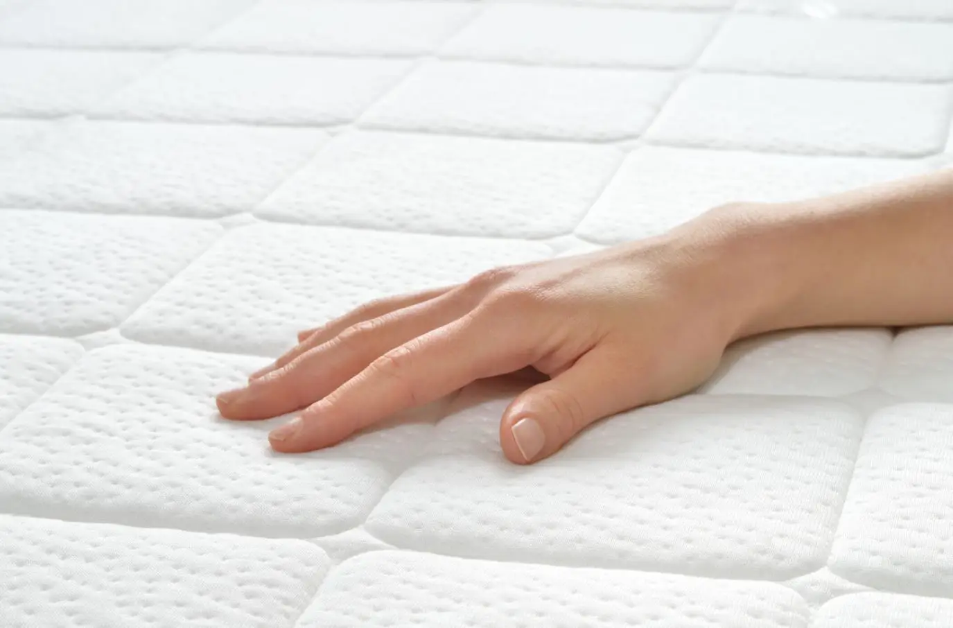 woman's hand on a white plush mattress