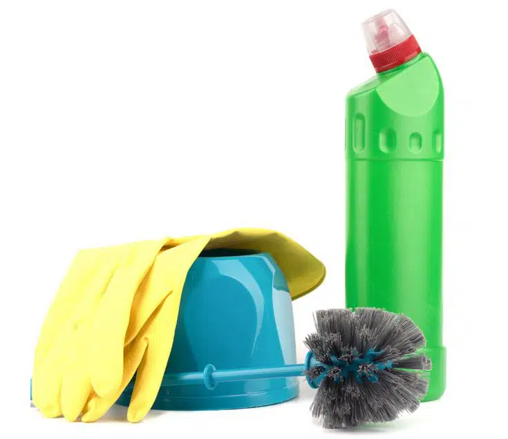 yellow gloves draped over blue toilet brush and toilet brush holder